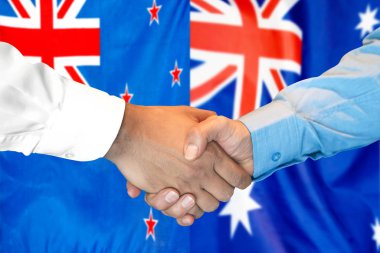 Yeni Zelanda ve Avustralya bayrak arka planında el sıkışma.