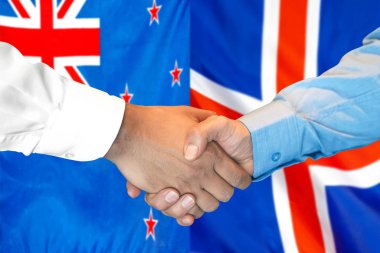 Yeni Zelanda ve İzlanda bayrak arkaplanında el sıkışma.