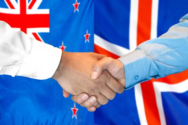 新西兰和冰岛国旗背景握手. — 图库照片