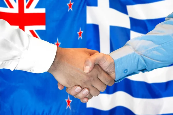 Uścisk dłoni na tle flagi Nowej Zelandii i Grecji. — Zdjęcie stockowe