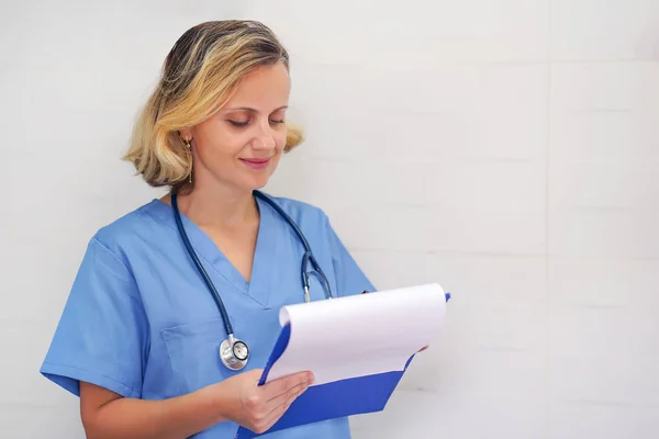 Nöjd läkare checkar rapport. Kvinnlig läkare kontrollerar medicinsk rapport. — Stockfoto