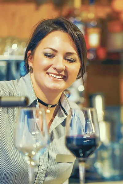 Ragazza barista versa vino rosso in due bicchieri di vino — Foto Stock
