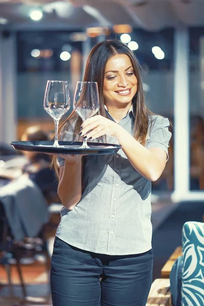 De serveerster is het dragen van een wijnglazen — Stockfoto