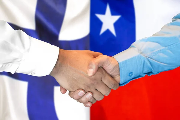 Potřesení rukou na pozadí vlajky Finska a Chile. — Stock fotografie