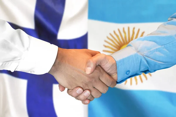 Handslag på Finland och Argentina flagga bakgrund. — Stockfoto