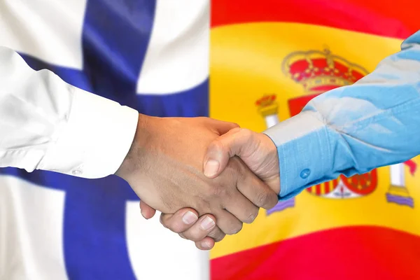 Handslag på Finland och Spanien flagga bakgrund. — Stockfoto