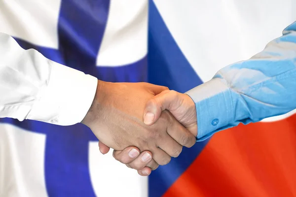 Uścisk dłoni na tle bandery Finlandii i Republiki Czeskiej. — Zdjęcie stockowe