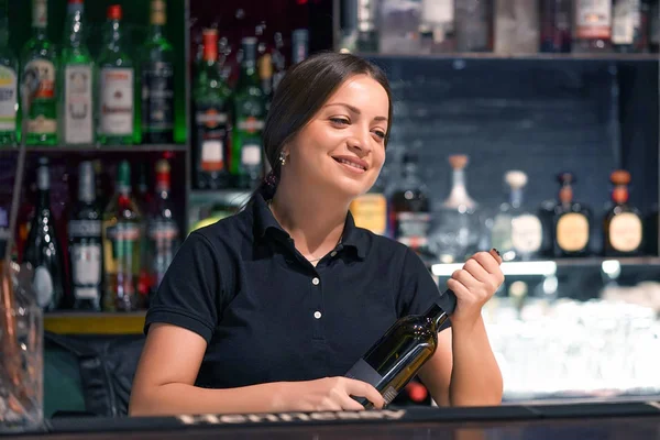 La cameriera apre una bottiglia di vino bianco — Foto Stock