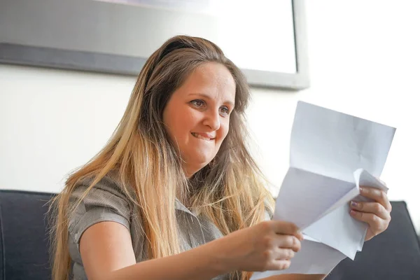 幸せな起業家の女性がソファに手紙で良いニュースを読む — ストック写真