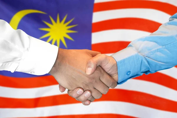 Handslag på Malaysia flagga bakgrund. — Stockfoto