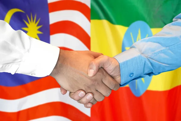 Stretta di mano su sfondo bandiera Malesia ed Etiopia . — Foto Stock