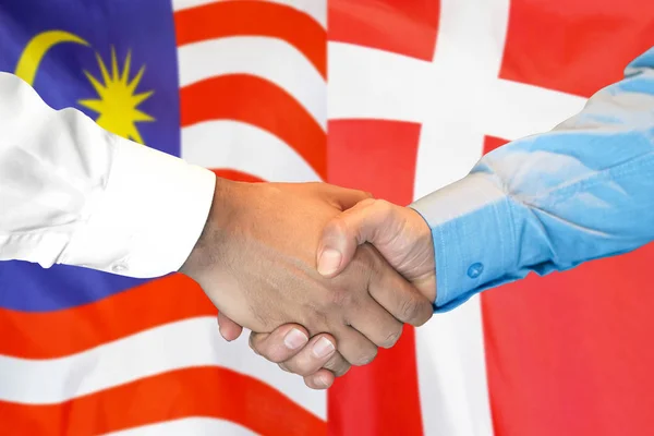 Handslag på Malaysia och Danmark flagga bakgrund. — Stockfoto