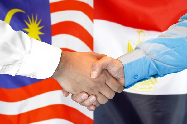 Jabat tangan di Malaysia dan Mesir bendera latar belakang . — Stok Foto