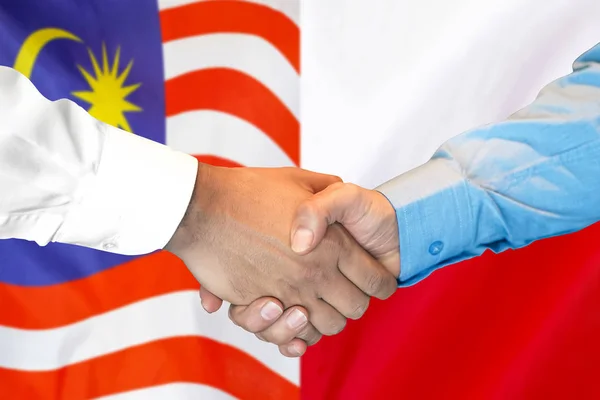 Handslag på Malaysia och Polen flagga bakgrund. — Stockfoto
