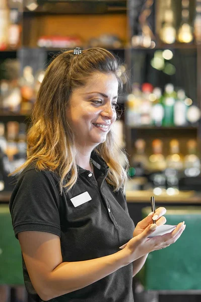 Smiling waitress taking an order in a restaurant