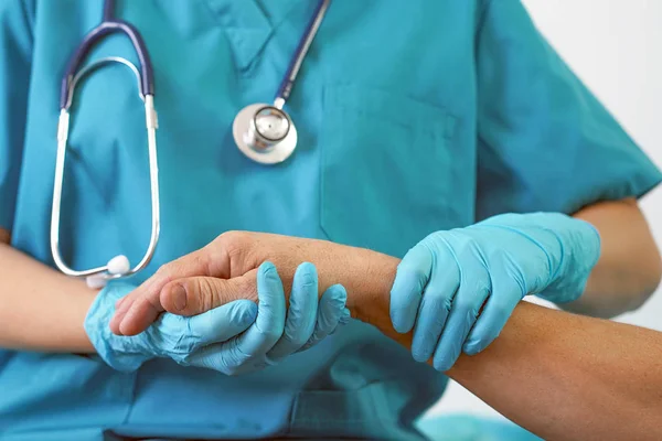 Doktor cesaretlendirmek ve empati kurmak için erkek hastanın elini tutuyor. Kötü haber ve destek.