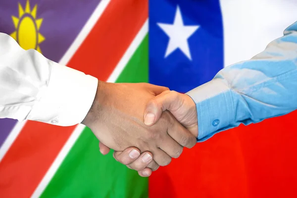 Potřesení rukou na pozadí Namibie a Chile vlajky. — Stock fotografie