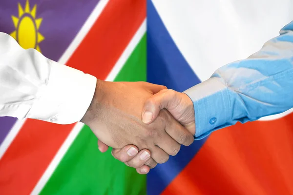 Handdruk op Namibië en Tsjechië vlag achtergrond. — Stockfoto