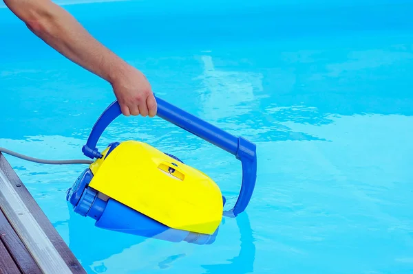 Hotel staff worker cleaning the pool. Automatic pool cleaners. — Stock Photo, Image