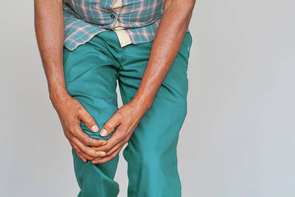 Hombre africano mayor sintiendo dolor en las articulaciones, tener problemas de salud y tocar la pierna con las manos . —  Fotos de Stock