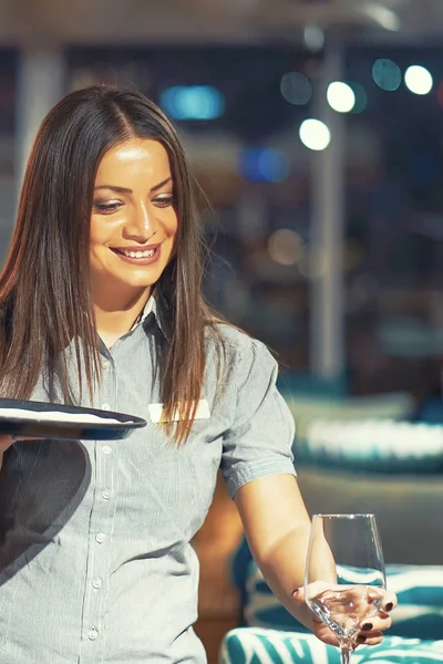 De serveerster is het dragen van een wijnglazen. — Stockfoto