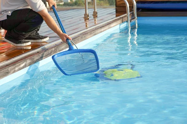 Automatic pool cleaners. Hotel staff worker cleaning the pool.