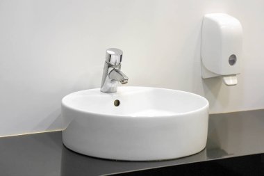 Modern beyaz lavabo musluklu. Banyo esprisi.
