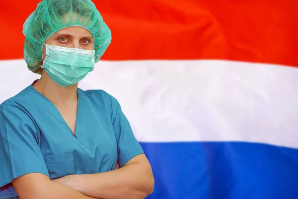 Kvinna kirurg på bakgrunden av den nederländska flaggan. Sjukvård, kirurgi och medicinskt koncept i Nederländerna. — Stockfoto