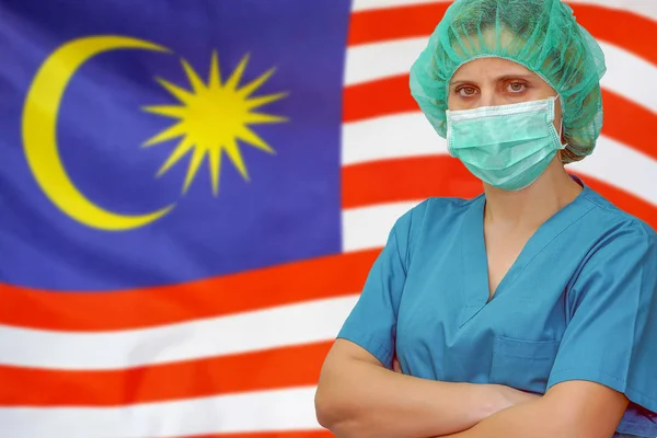 Kvinna kirurg på bakgrunden av Malaysia flaggan. Sjukvård, kirurgi och medicinskt koncept i Malaysia. — Stockfoto