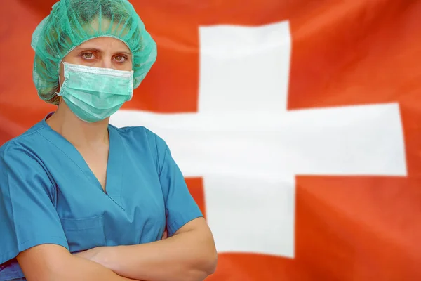 Woman surgeon on the background of the Switzerland flag. Health care, surgery and medical concept in Switzerland.