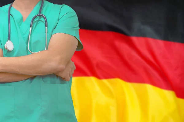 Male surgeon or doctor with stethoscope on the background of the Germany flag. Health care and medical concept. Surgery concept in Germany.