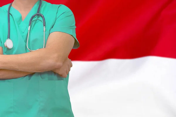 Male surgeon or doctor with stethoscope on the background of the Monaco flag. Health care and medical concept. Surgery concept in Monaco.