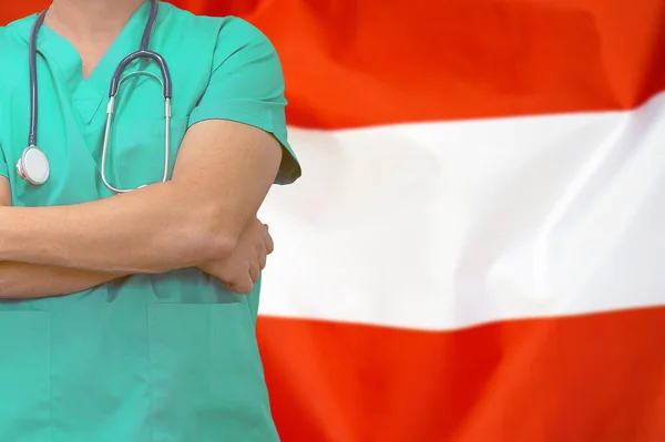 Male surgeon or doctor with stethoscope on the background of the Austria flag. Health care and medical concept. Surgery concept in Austria.