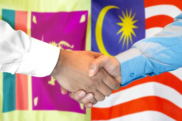 在两面旗帜的背景下进行商业握手 男子在斯里兰卡和马来西亚国旗的背景下握手 支助概念 — 图库照片