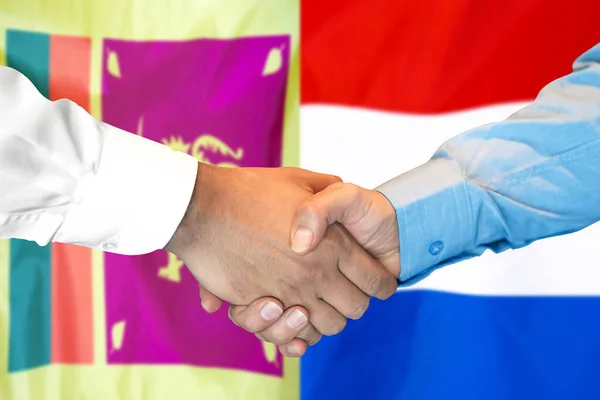 2つのフラグの背景にビジネス握手 スリランカとオランダの国旗を背景に男性が握手をする サポートコンセプト — ストック写真