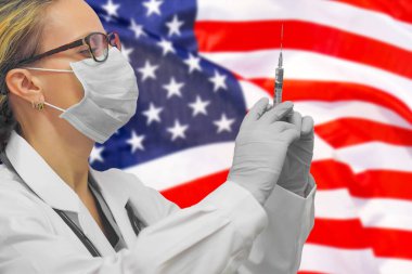Eldivenli kadın doktor ya da hemşire, ABD bayrağının arka planına karşı aşı için şırınga tutuyordu. Tıp konsepti ve virüsle savaş. ABD 'de Coronavirus.