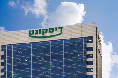 Tel Aviv 'in merkezindeki İsrail İndirim Bankası' nın üzerinde mavi bulutlu gökyüzüne karşı İbrani logosu olan bir tabela. İsrail bankasının logosu olan bina. 5 Ekim 2017. İsrail.