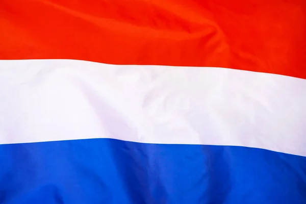 Fabric texture flag of Netherlands. Flag of Netherlands waving in the wind. Netherlands flag is depicted on a sports cloth fabric with many folds. Sport team banner.