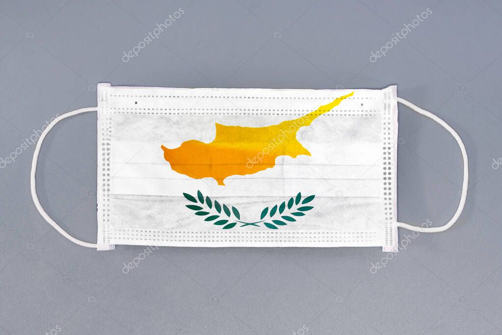 Isolated medical mask with flag of Cyprus on gray background. Closeup protective masks textile filter. Health care and medical concept. Coronavirus, virus in Cyprus.