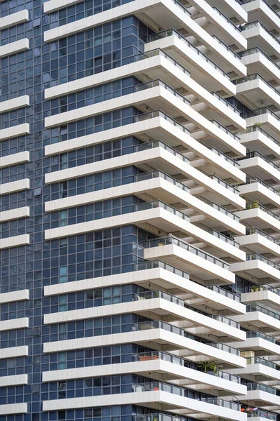 altas casas de vidro azul e branco estão alinhadas em altura. casas são  feitas no mesmo estilo. novo microdistrito, casas com janelas panorâmicas.  contra o fundo de nuvens escuras 13416798 Foto de stock no Vecteezy