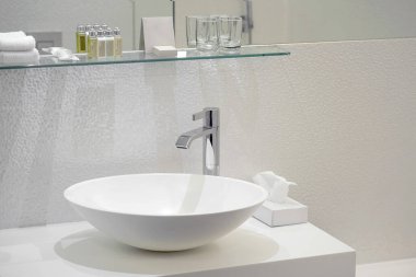 Lavabo ve musluğu olan bir banyo. Lüks otellerde modern tasarımla banyo içi lavabo..