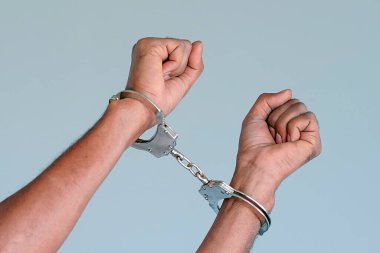 Elleri kelepçeli Afrikalı bir adam tutuklanmış. Tutuklu ya da tutuklu, elleri kelepçeli, seçici odaklı..