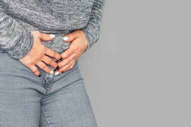 Karın ağrısı var. Karın ağrısı çeken kadın gri arka planda izole edilmiş. Jinekoloji ve sağlık hizmetleri kavramı. Kronik gastrit. Vücut ve Sağlık Hizmetleri Konsepti. Metinleriniz için yer, kopyalama alanı.