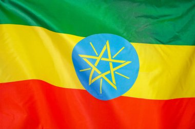 Etiyopya 'nın kumaş desenli bayrağı. Etiyopya bayrağı rüzgarda dalgalanıyor. Etiyopya bayrağı birçok katlı bir spor kumaşı üzerinde tasvir edilir. Spor takımı afişi.