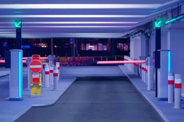 Yeraltı otoparkından çıkış. Yeraltı otoparkı. Otoparkın girişinde ve çıkışında bariyer var. Otoparkta bir bariyer. Park yerinin içi