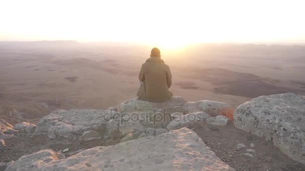 Hombre en el borde de un acantilado al amanecer — Vídeos de Stock