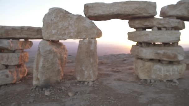 El hombre camina hacia una estructura de piedra en una mañana desértica — Vídeos de Stock