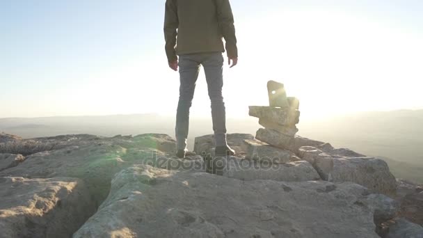 Hombre de pie en la cima de un acantilado del desierto en el sol de la mañana — Vídeo de stock