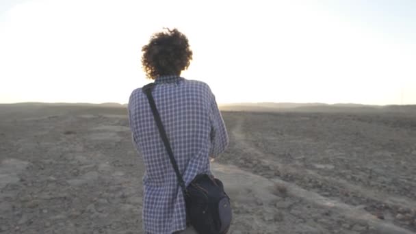 Jovem tira uma foto do sol do deserto — Vídeo de Stock