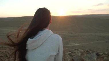 Genç erkek çölde güneş kümesinde izlerken